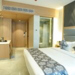 A modern hotel room with a bed and bathroom.